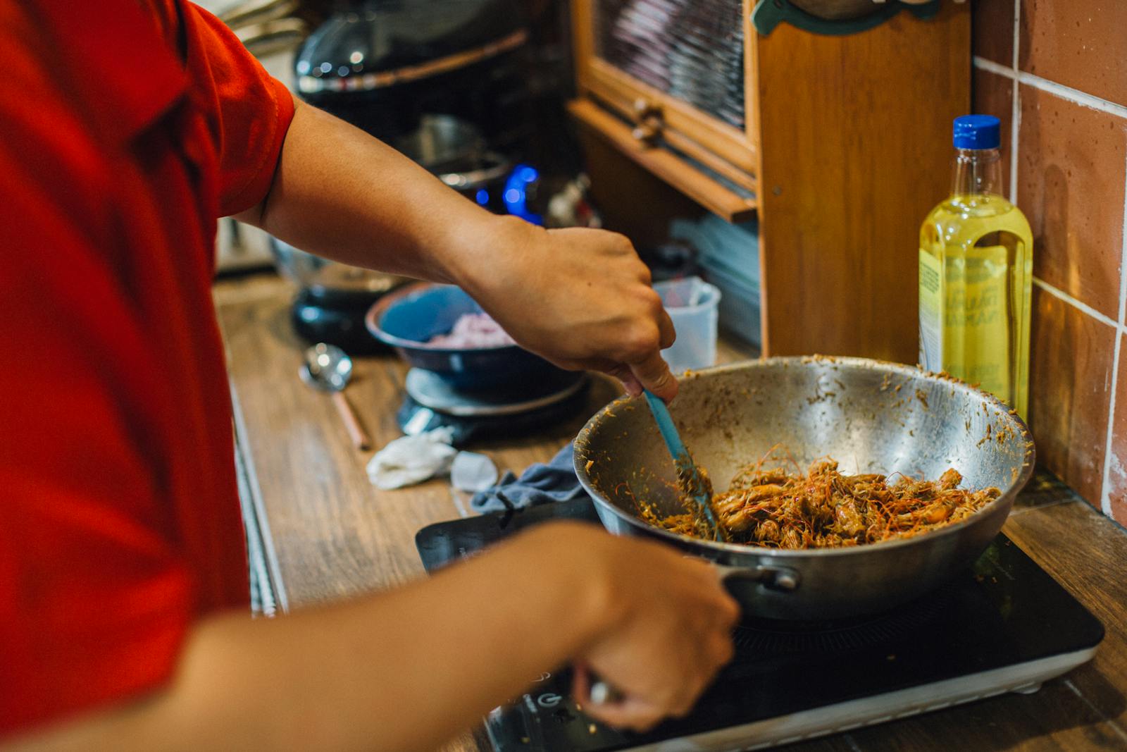 Person cooking an Asian dish in a home kitchen, representing the kind of practical upgrades that support modern home chefs every day.