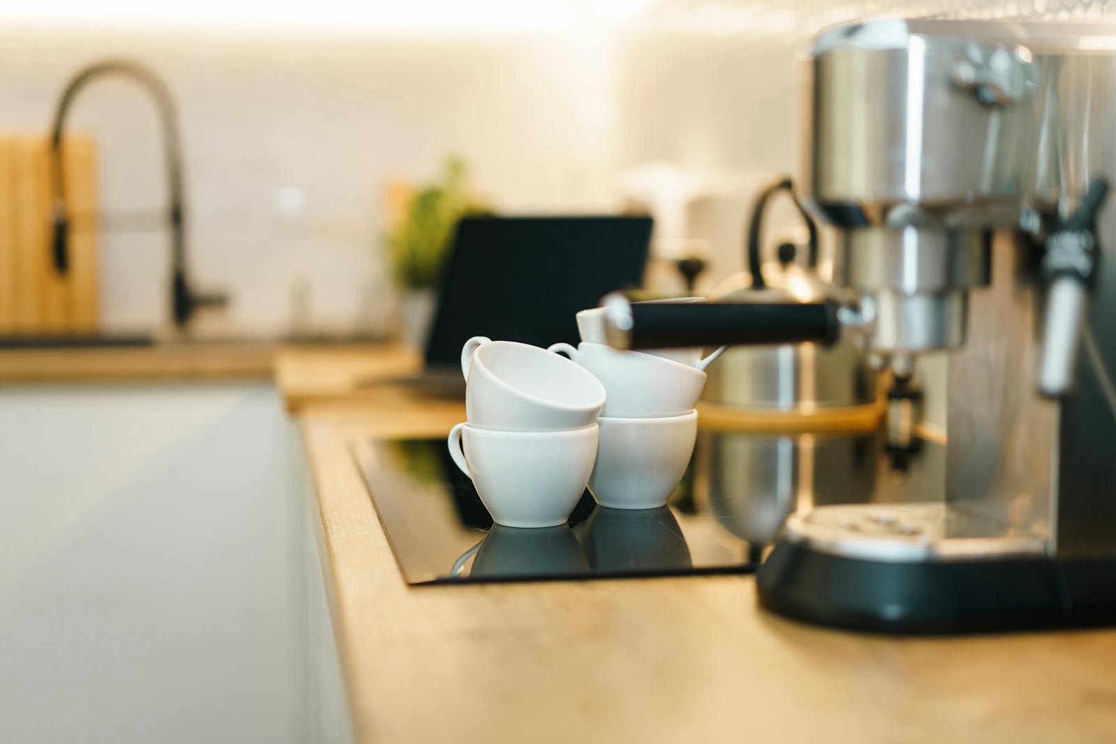 Modern home espresso station with espresso machine, cups, and a clean coffee corner setup.