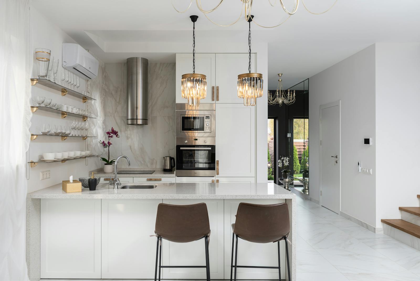 Stylish kitchen with layered pendant, under-cabinet, and ambient lighting.