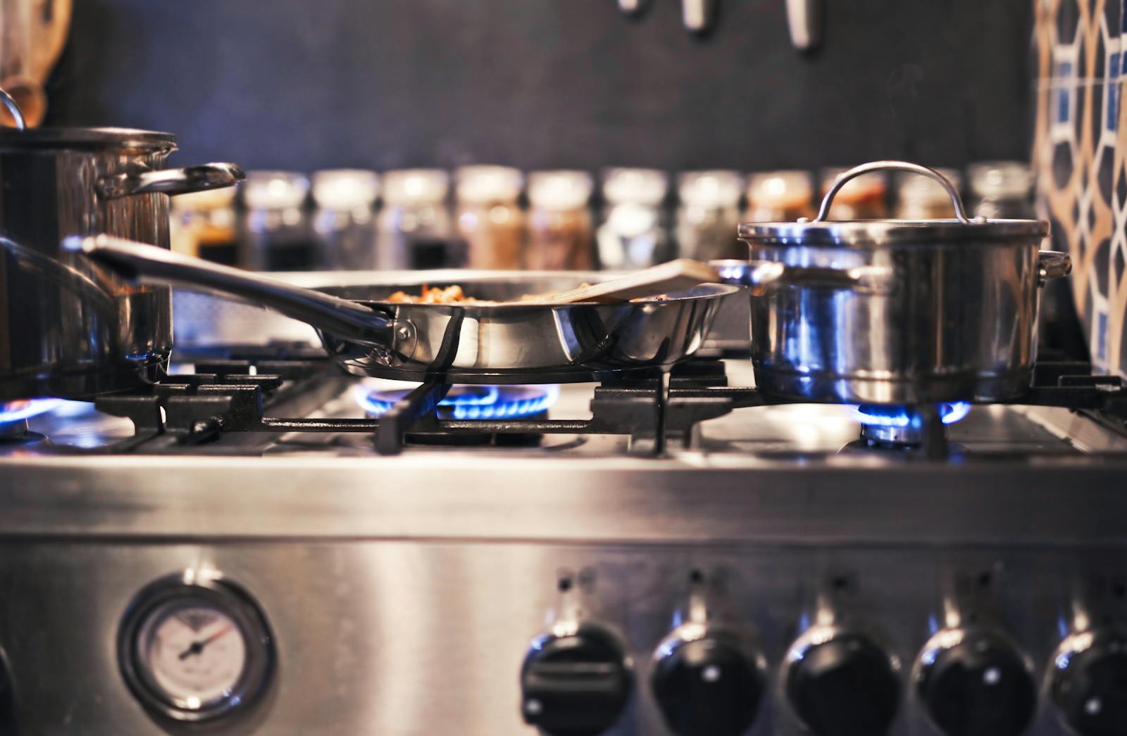 Stainless steel cooking pot on a stove in a clean kitchen, representing a simpler, more practical approach to kitchen organization and daily use.