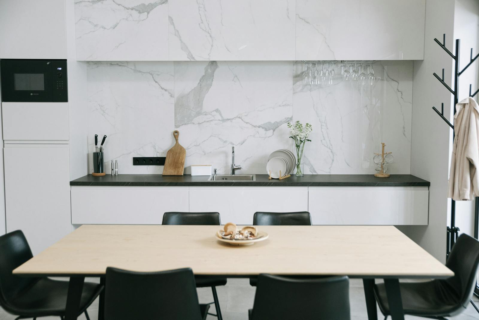 Modern kitchen and dining area with a calm, refined atmosphere, representing the move toward quieter acoustic kitchen design.
